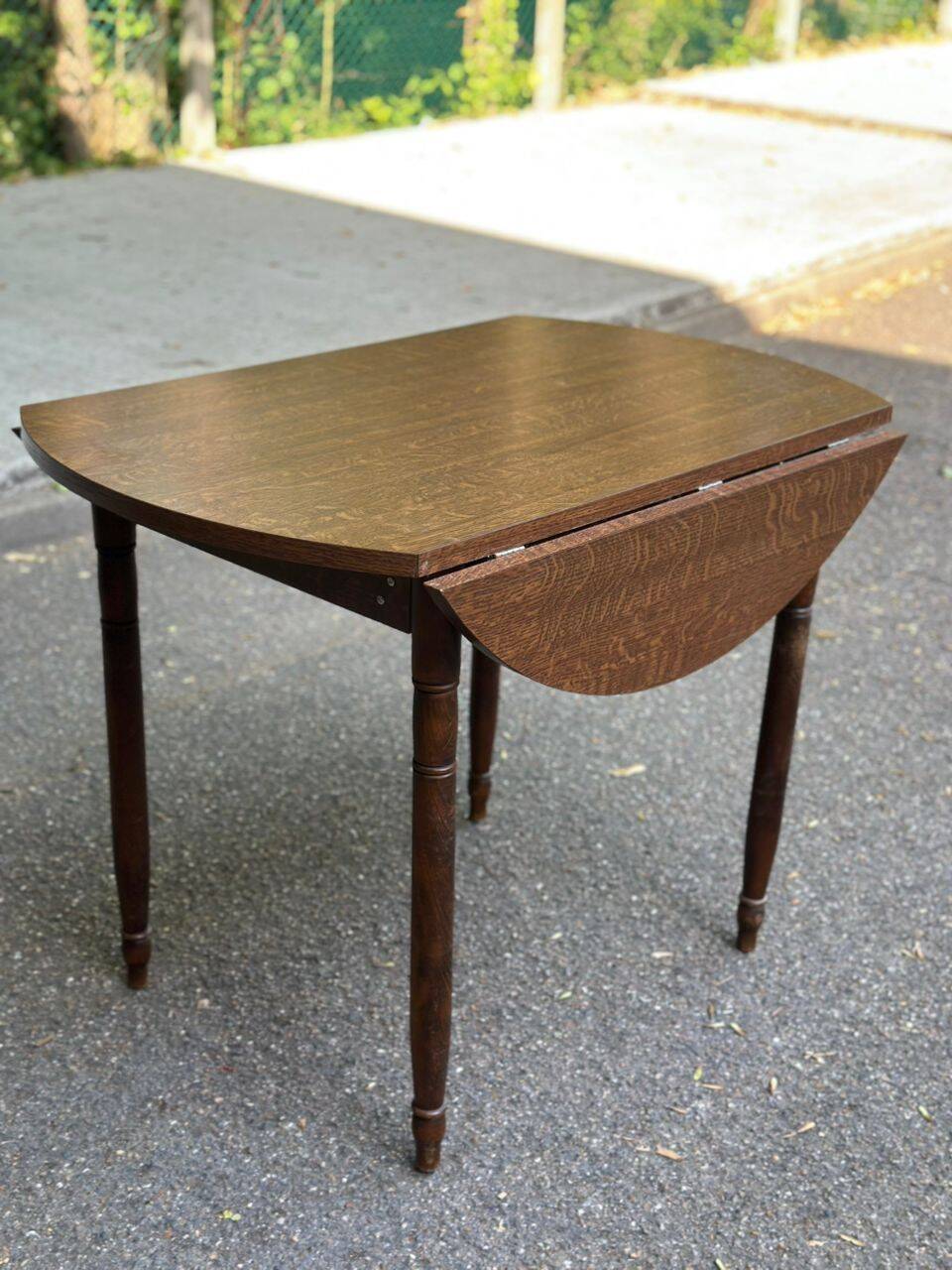 Round kitchen table with extendable leaves in dark wood.