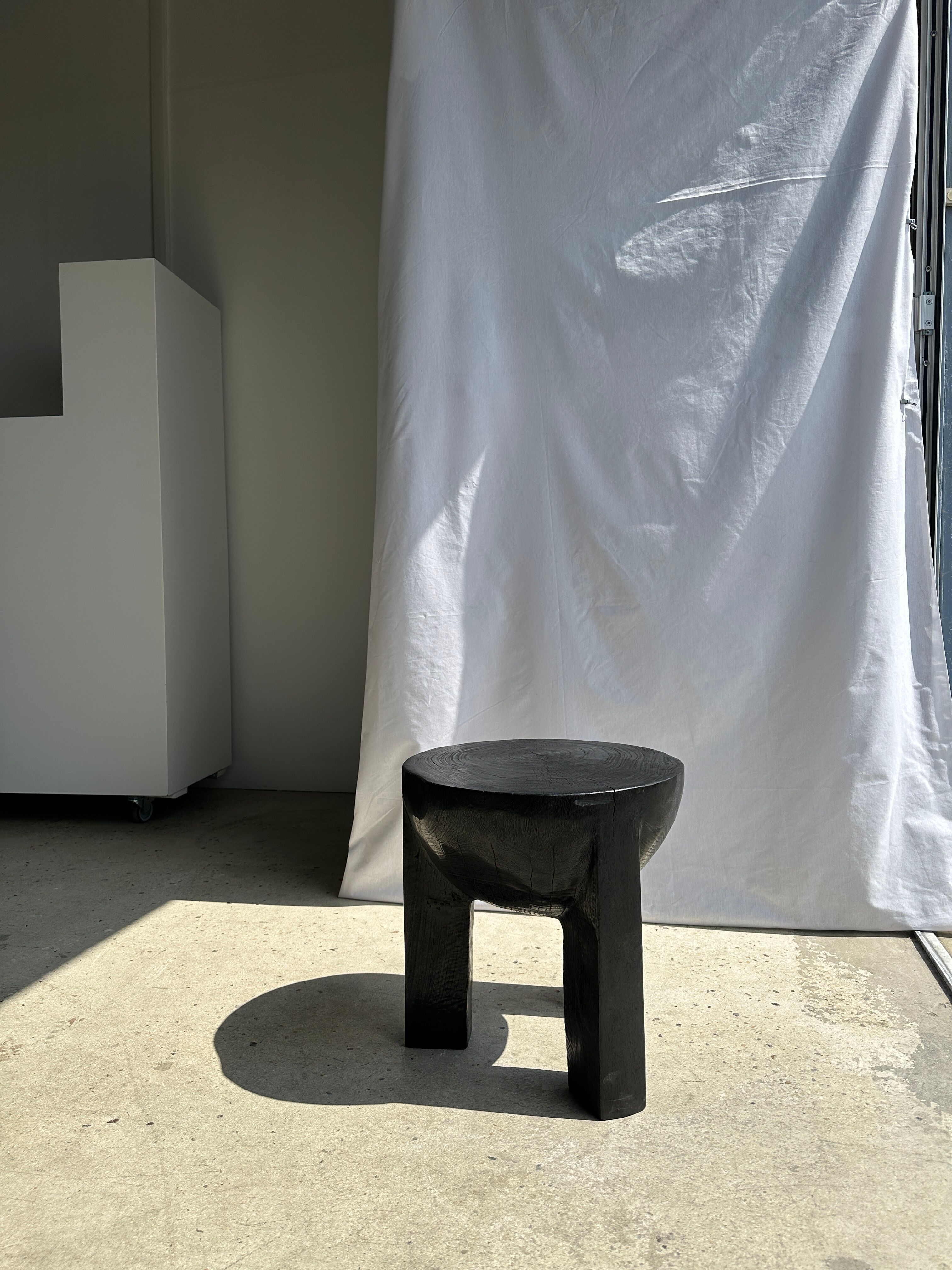 Black mango wood tripod side table with a semi-spherical top, height: 45 cm, diameter: 44 cm.
