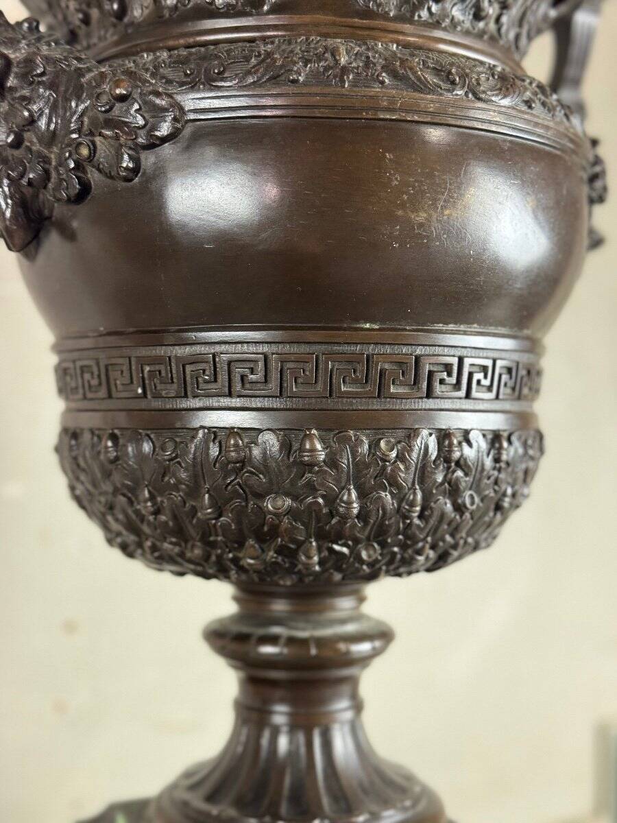 Patinated bronze vase with handles topped by bicéphalic busts, 19th century.