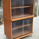Scandinavian wooden buffet cabinet with sliding glass doors.