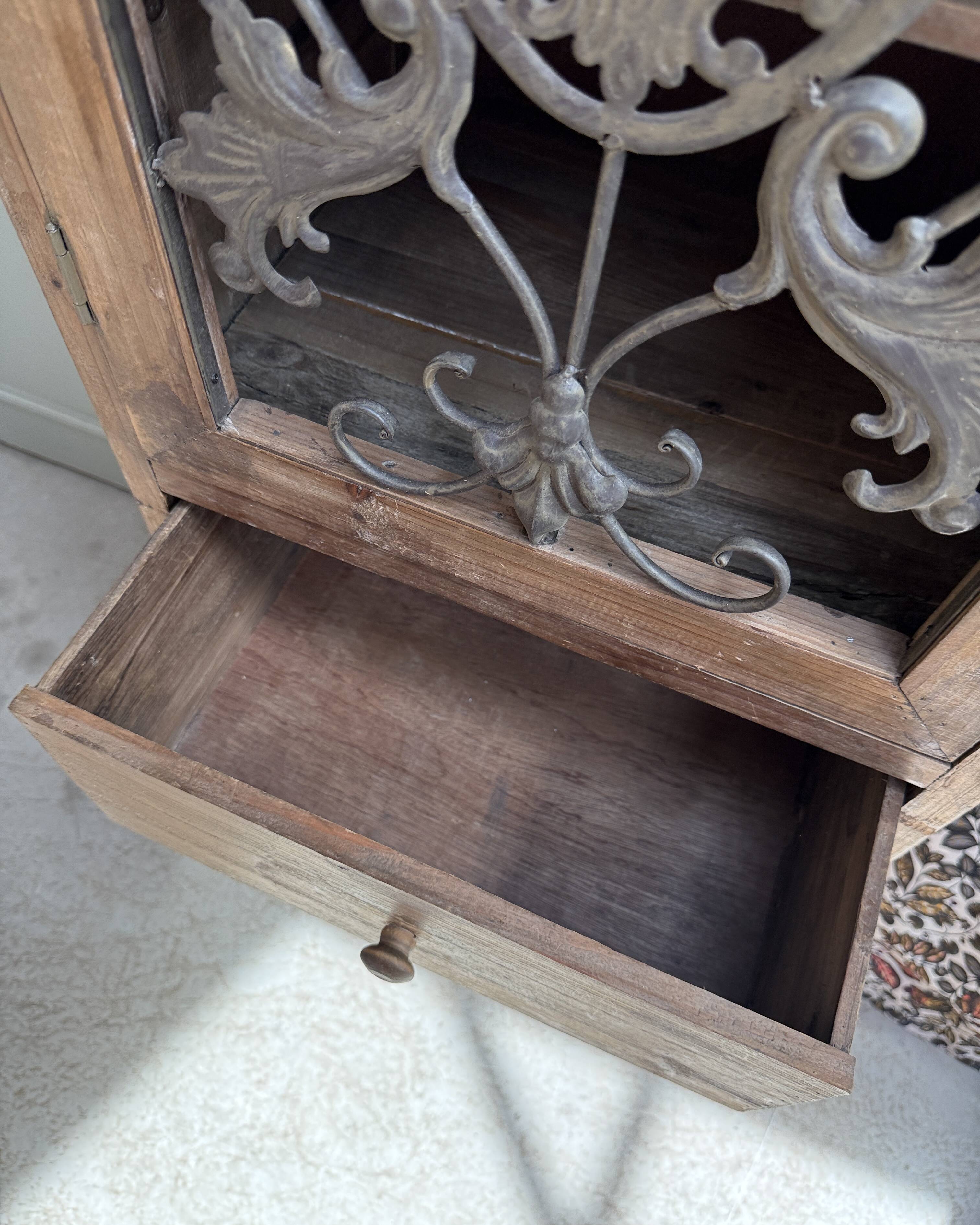 Column storage unit with a sculpted metal door.