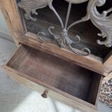 Column storage unit with a sculpted metal door.