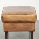 Cowhide ottoman with a beautiful patina finished with decorative nails