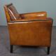 Art deco armchair in sheepskin with black piping and decorative nails