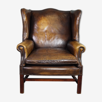 Patinated cowhide leather armchair