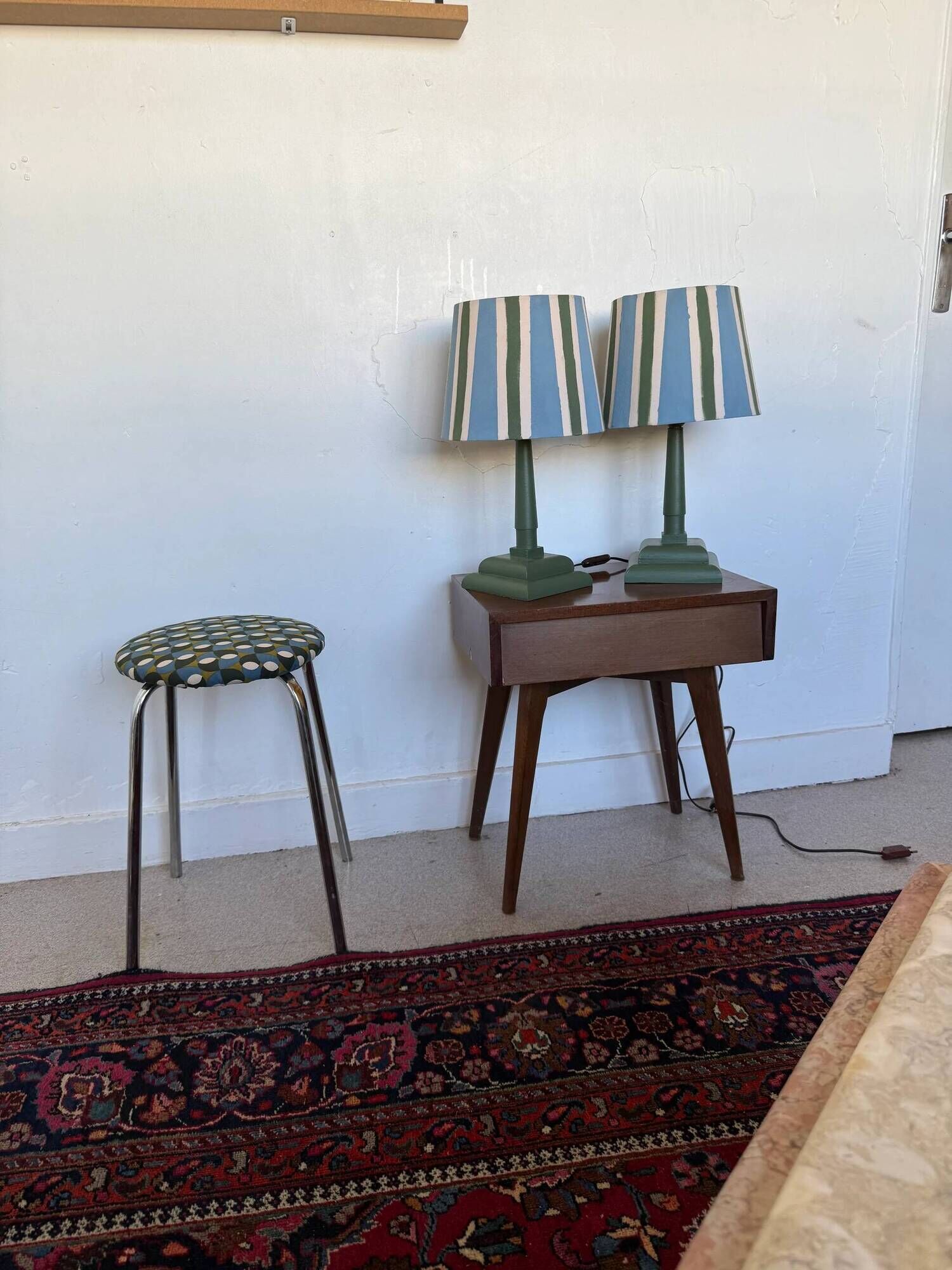 Pair of vintage wooden lamps with their striped beige, blue, and green shades.