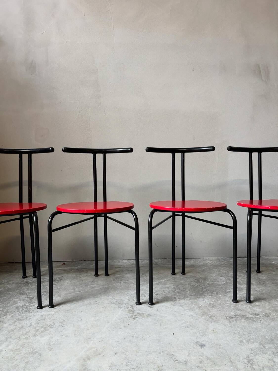 Set of 4 vintage black metal chairs with red lacquered seats.