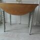 Walnut table with raised flaps, base on verdigris casters.
