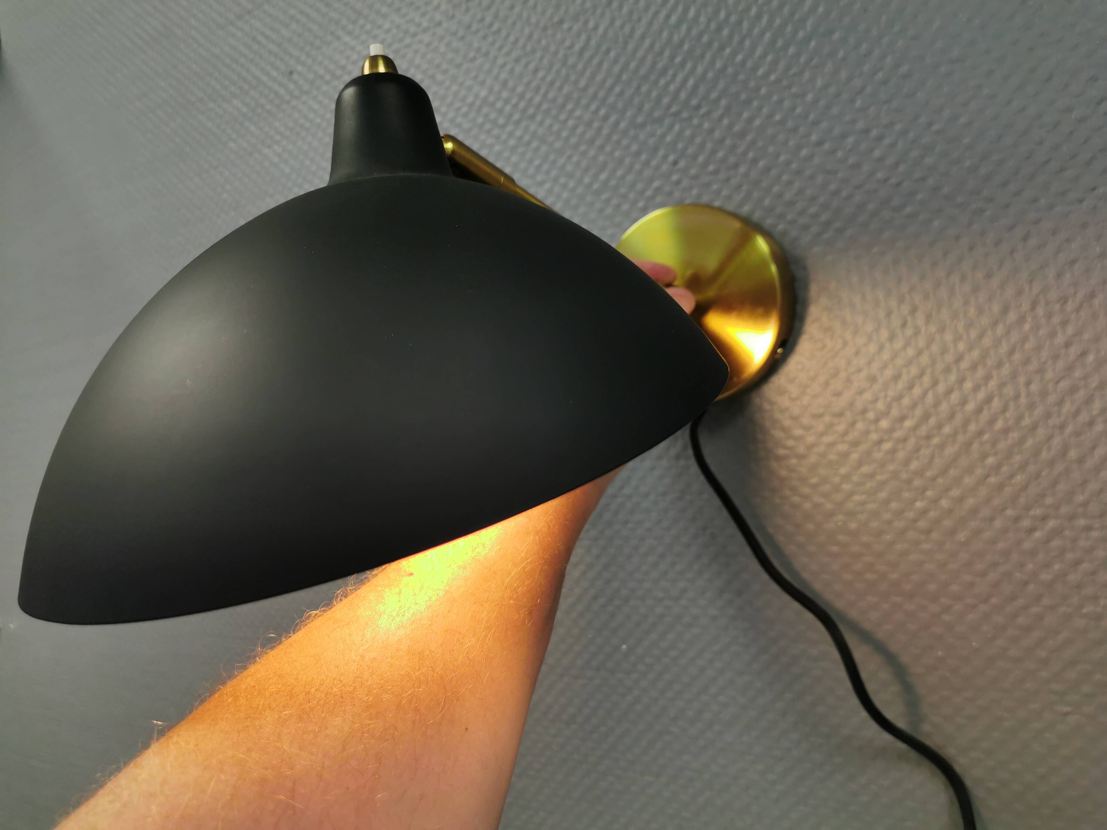 A wall lamp in black and brass-coloured finishes. Danish, early 2000s.