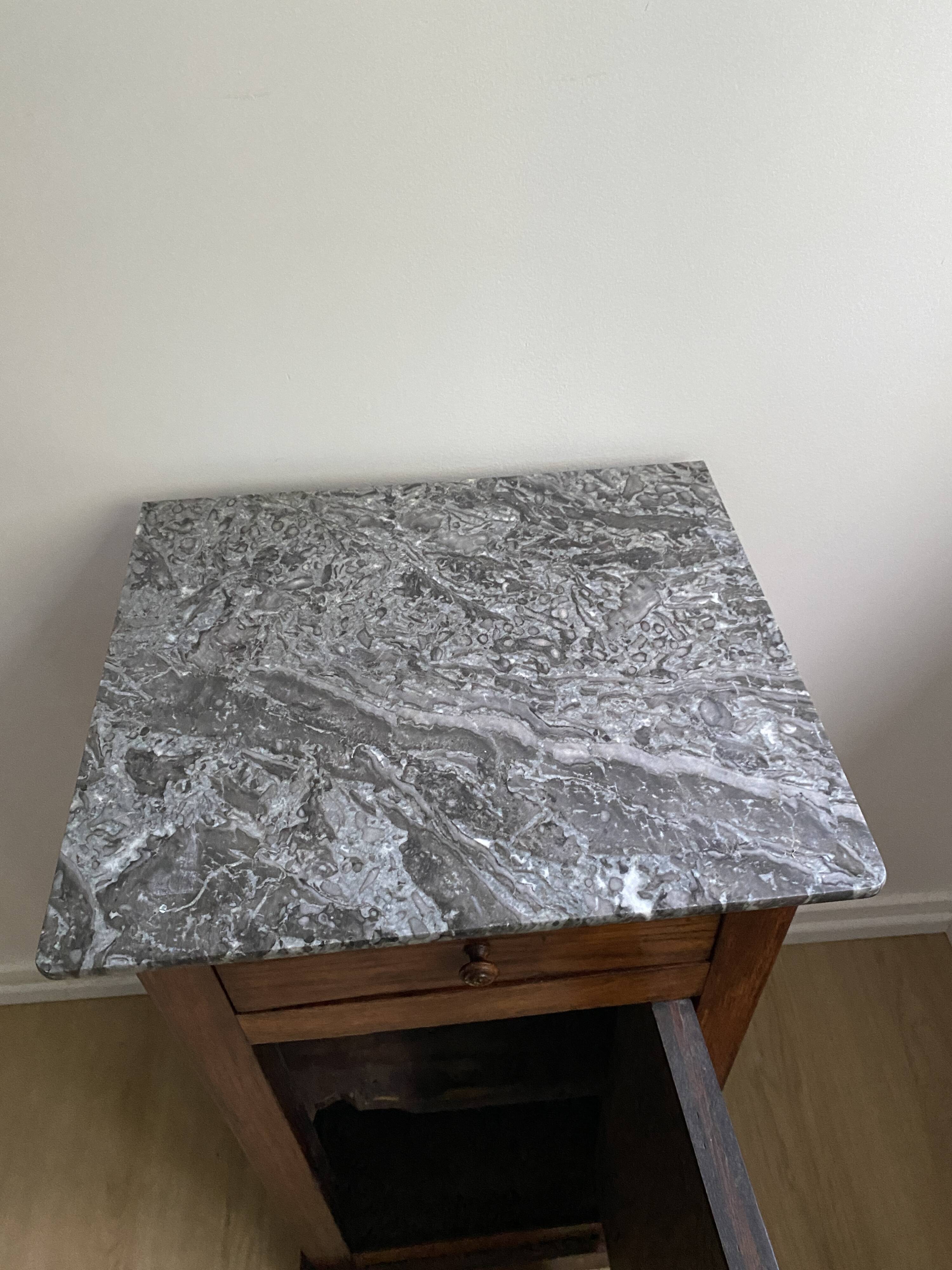 Vintage bedside table in the shape of a wooden column and a gray marble top