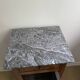 Vintage bedside table in the shape of a wooden column and a gray marble top