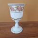 Footed glass in the shape of a chalice in white opaline with a floral decoration.