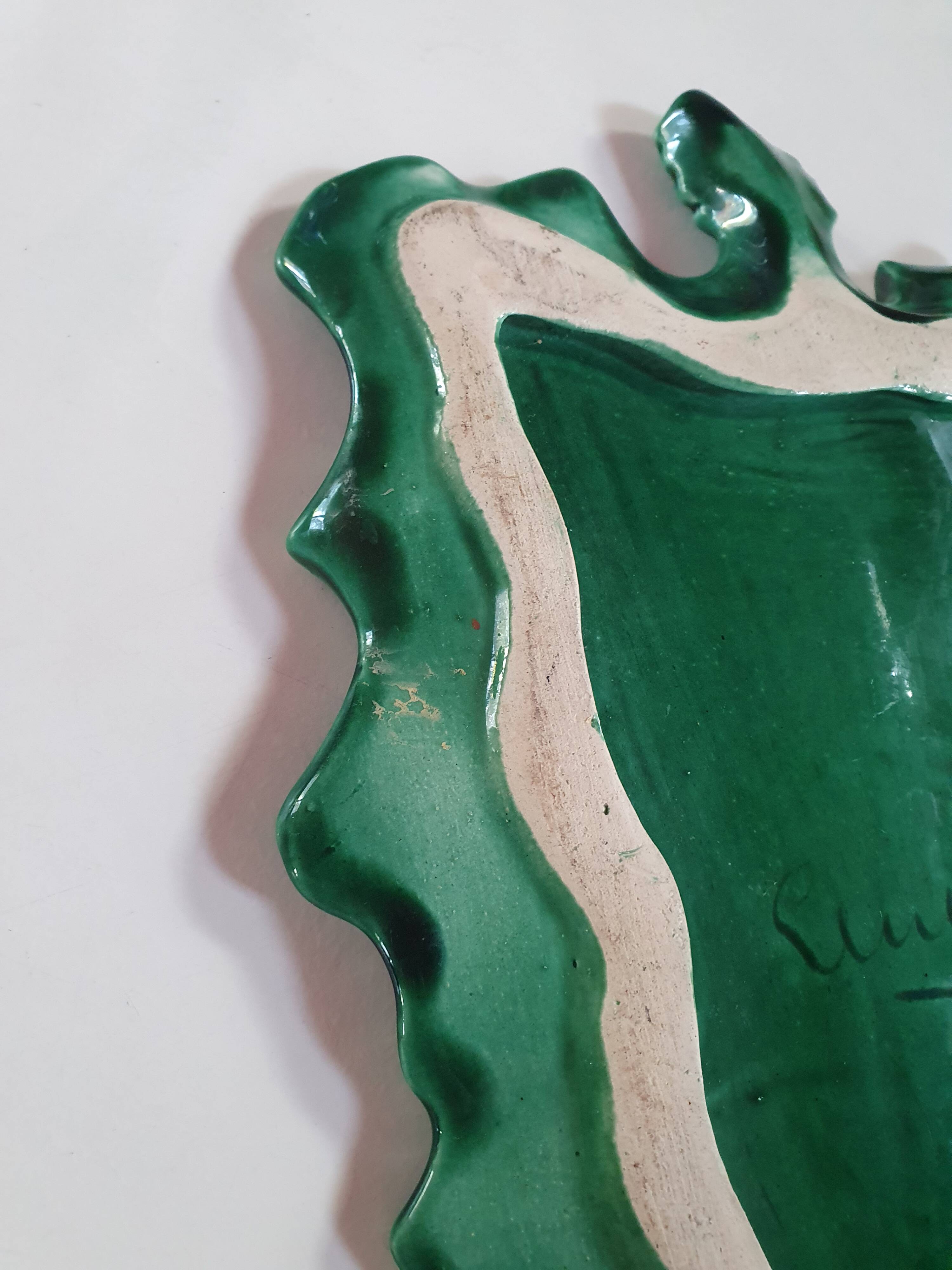 empty green ceramic pocket cup, small chips on the edges, signed