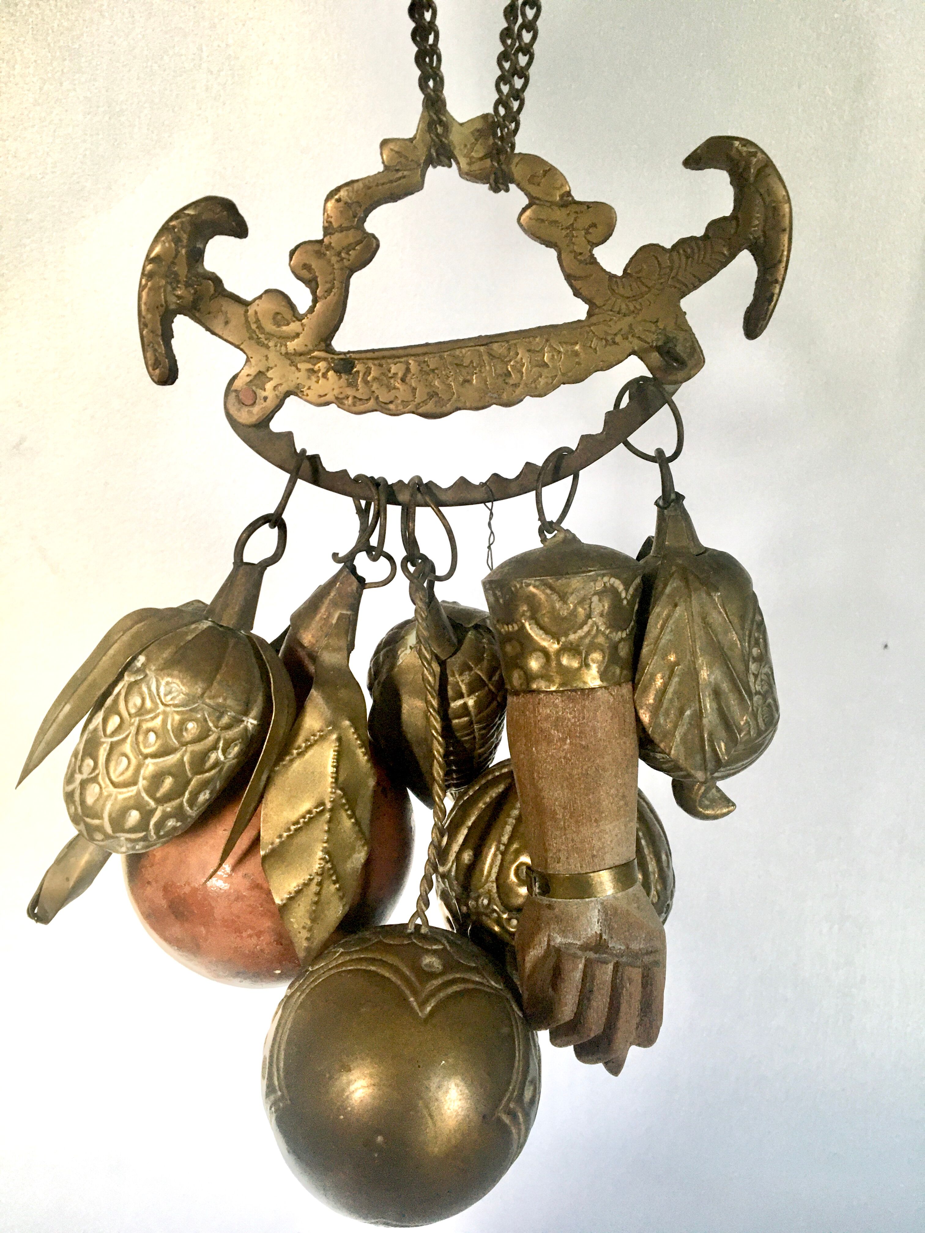 Wall decoration of brass and wood amulets
