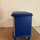 Small vintage upcycled side table in midnight blue and raw wood, with a rose-shaped door.