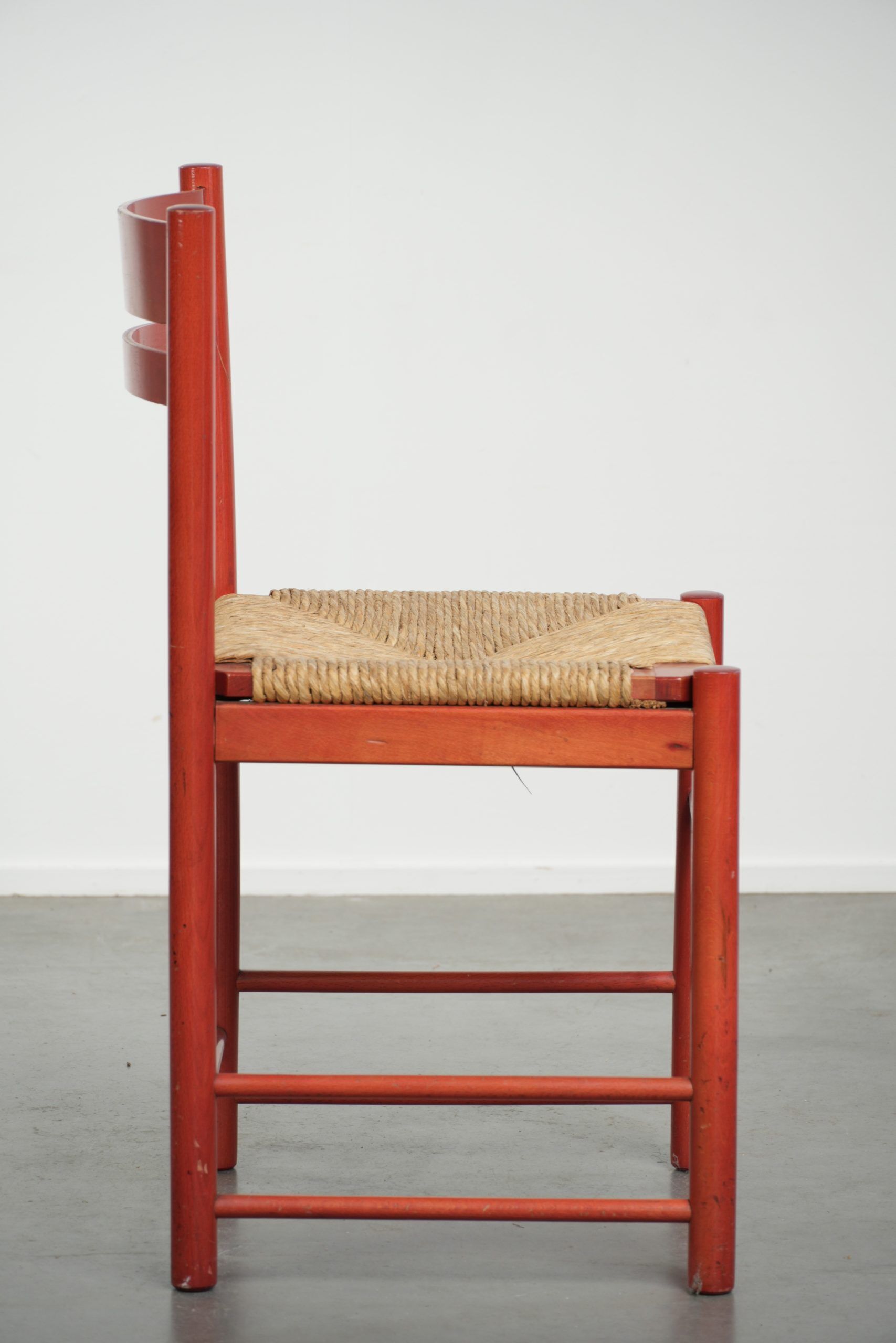 Red vintage wooden chair from the 1970s with a woven wicker seat
