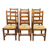 6 light solid wood chairs with high straw backs, farmhouse style.