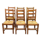 6 light solid wood chairs with high straw backs, farmhouse style.