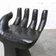 Black armchair chair in carved wood in the shape of a hand