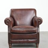 Sheepskin armchair with a classic finish and decorative studs.