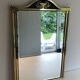 Neoclassical style mirror in brass and lacquered sheet metal.