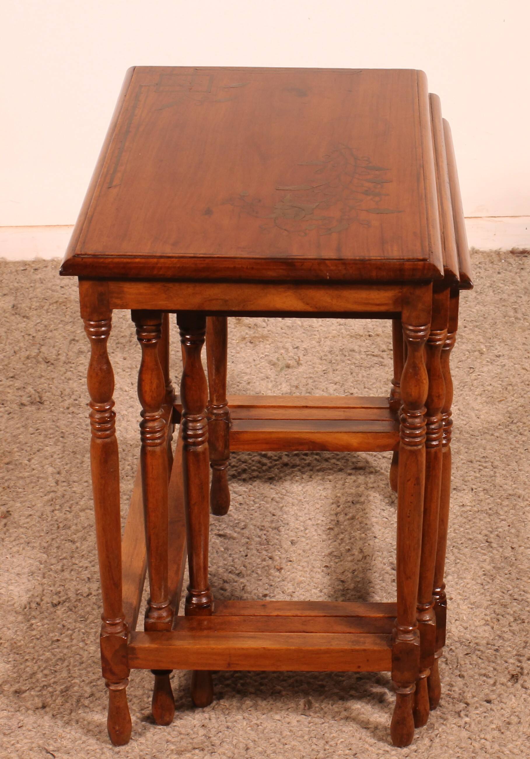 Nested tables in satin wood with brass inlays.