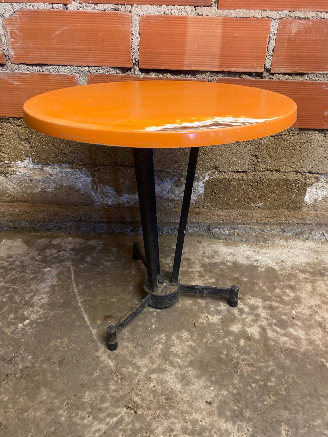 Vintage bistro table with black cast iron base and orange bakelite top, 1950s