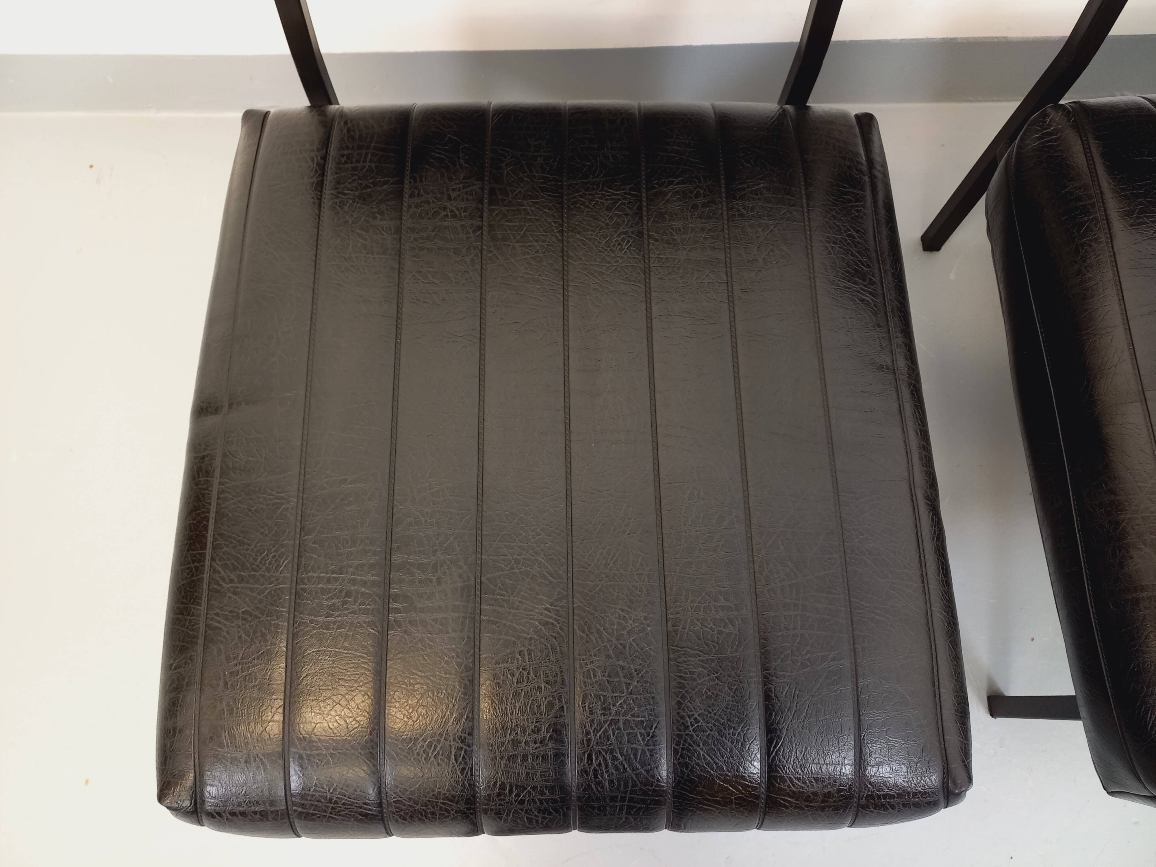 Set of 2 vintage modernist armchairs in black faux leather and metal.