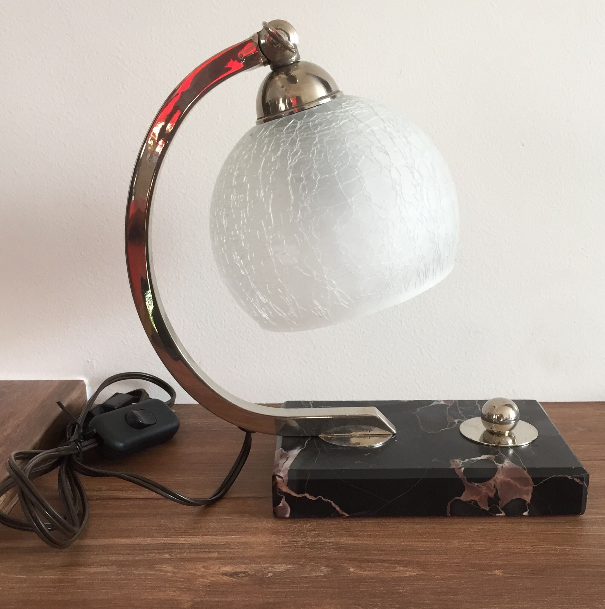 Art-deco lamp on marble with its original metal frame and the globe is cracked glass.