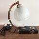 Art-deco lamp on marble with its original metal frame and the globe is cracked glass.