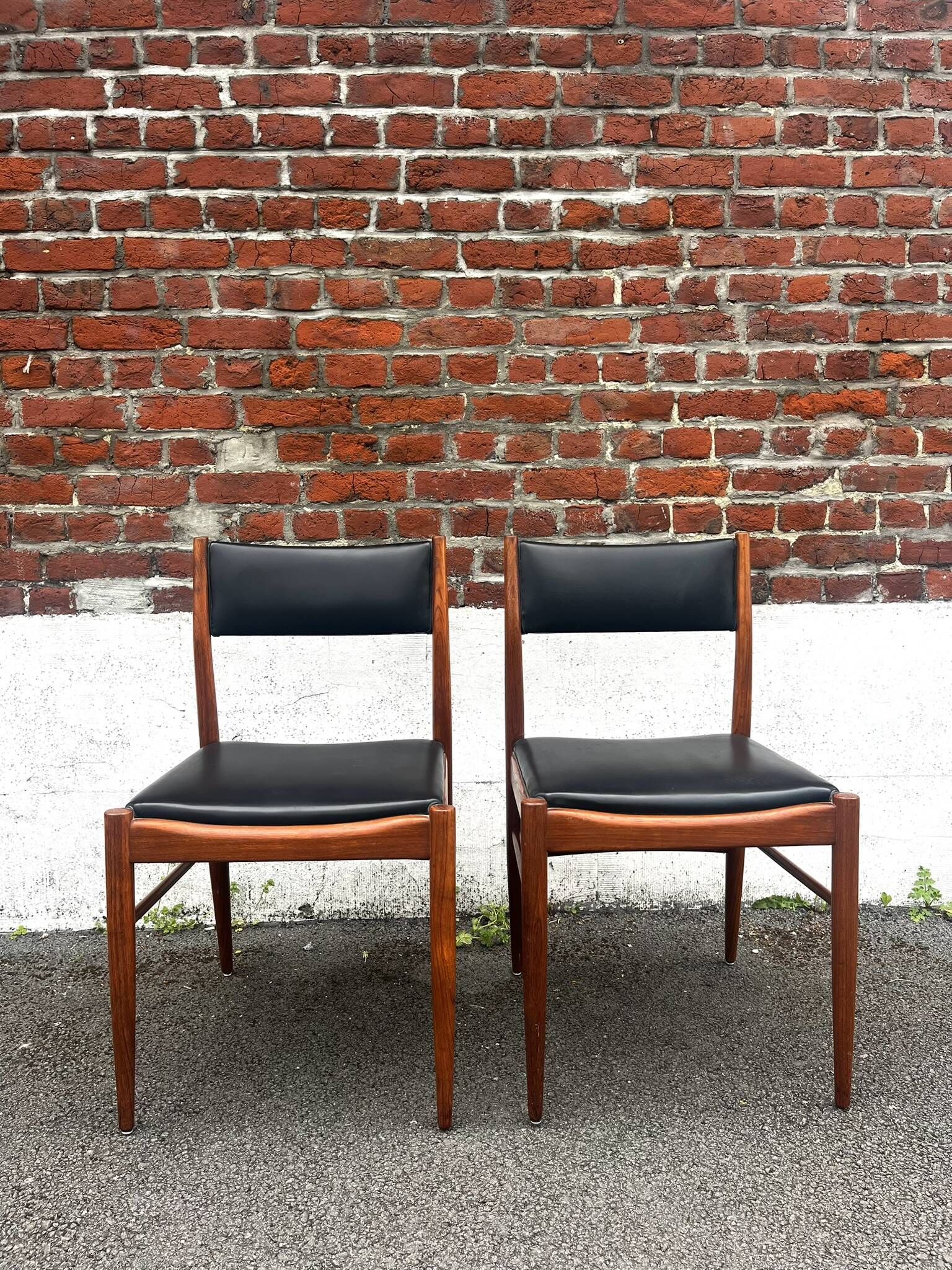 Set of 2 vintage Scandinavian chairs in wood and black faux leather.