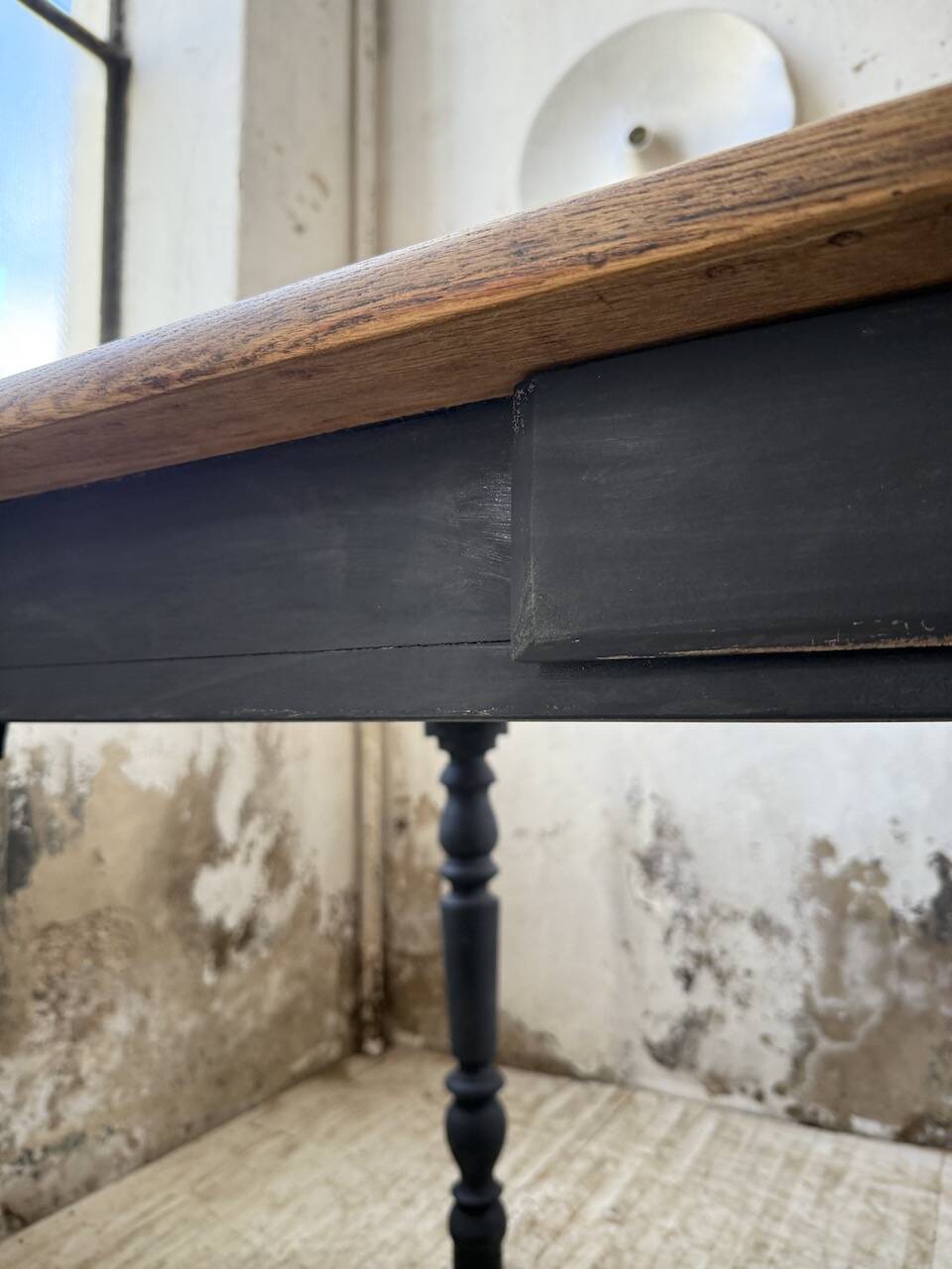 Oak farmhouse table with turned black legs.