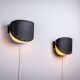 Matte black wall lamps with perforated shades and brass details