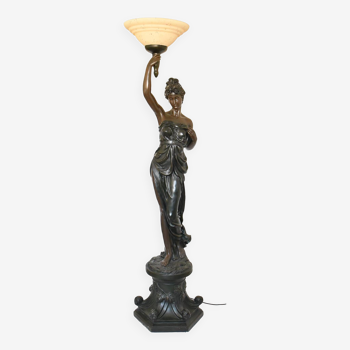 Lampadaire figurant une femme drapée à l'antique, le bras droit levé tenant une torche