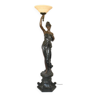 Floor lamp depicting a woman draped in antique style, her right arm raised holding a torch