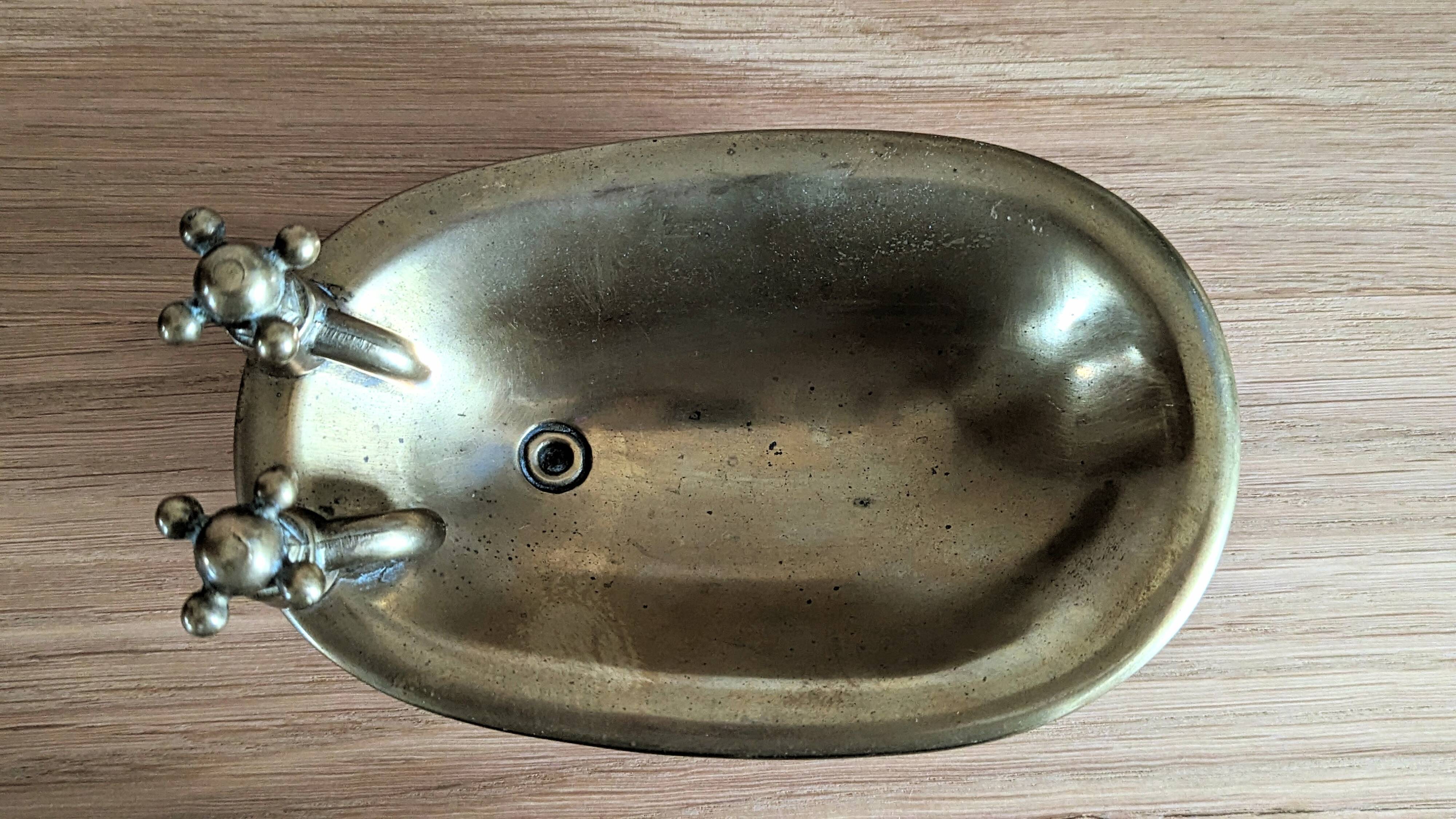 Old soap dish in the shape of a brass bathtub
