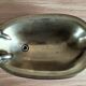 Old soap dish in the shape of a brass bathtub