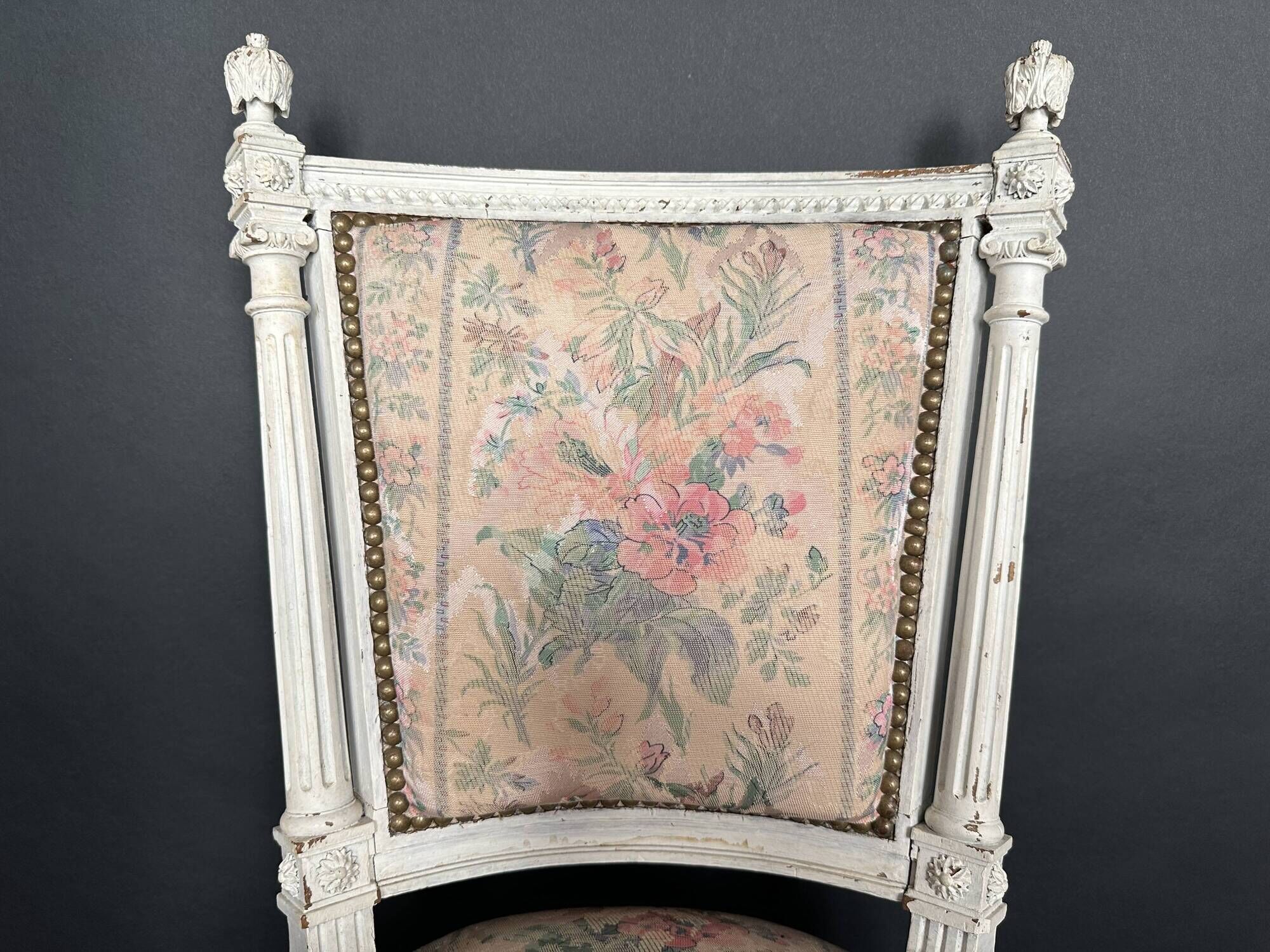 Antique Louis XVI style chair with patinated wood and floral fabric.