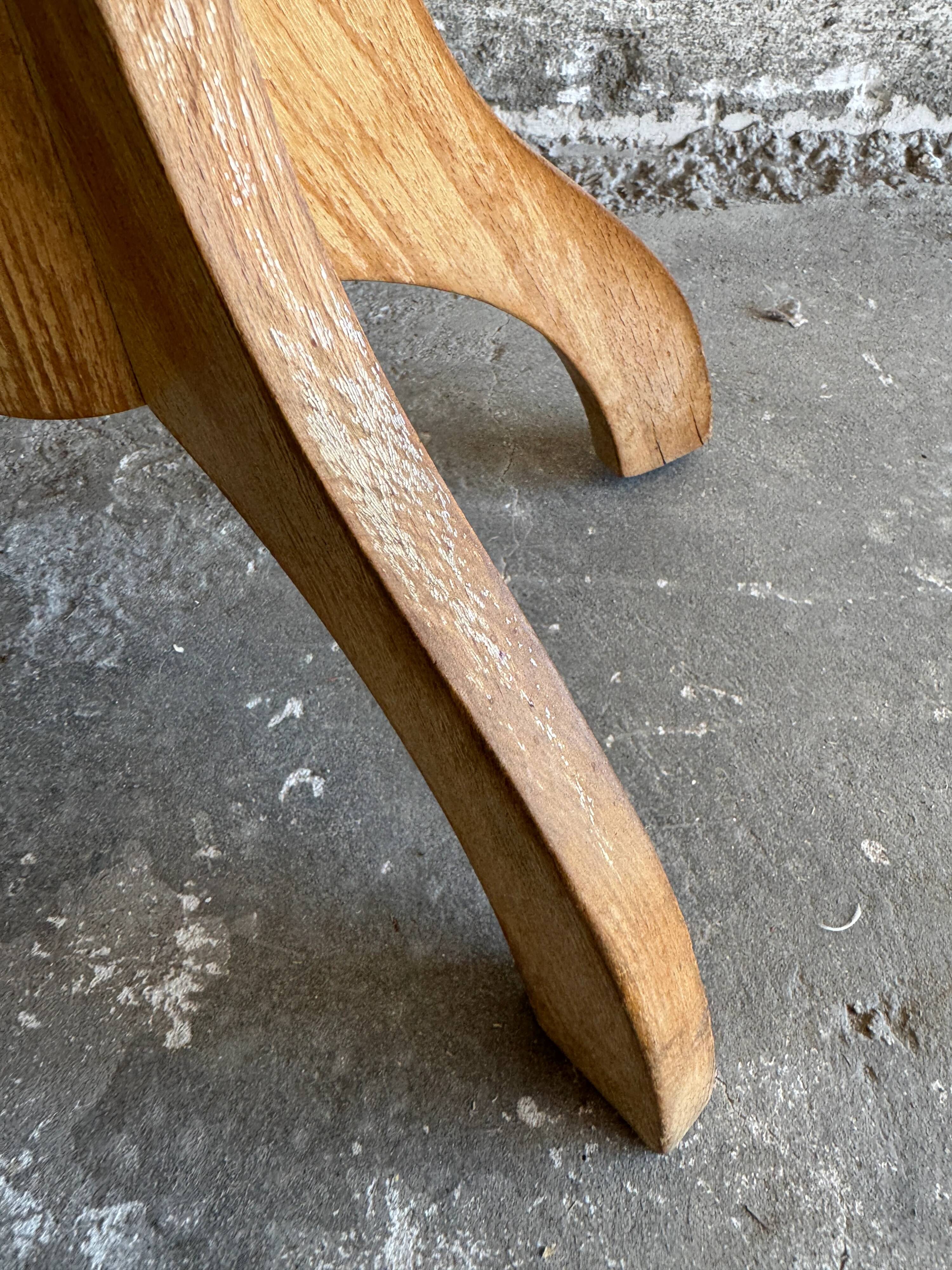 Vintage natural wood stool with light yellow faux leather seat and crossed splayed base