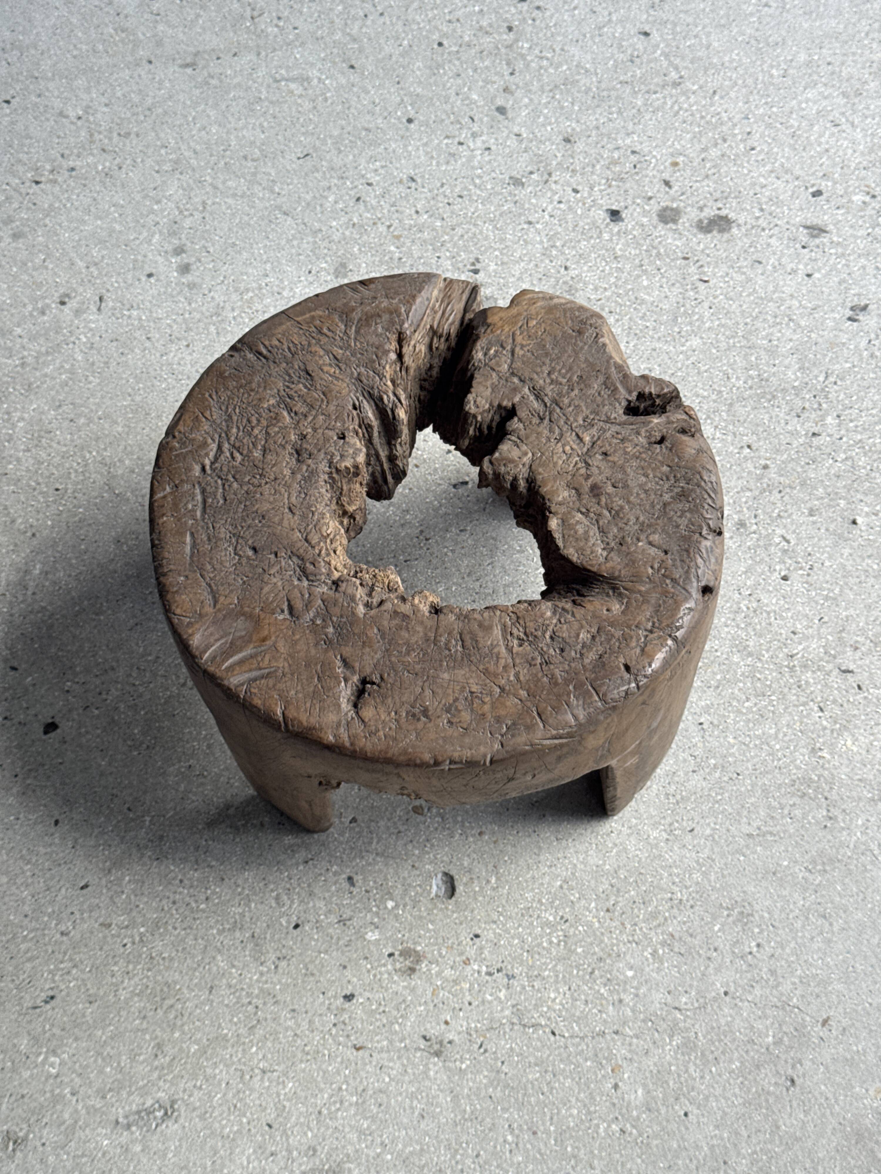 Small low circular four-legged stool in organic old teak with cut-out design H2
