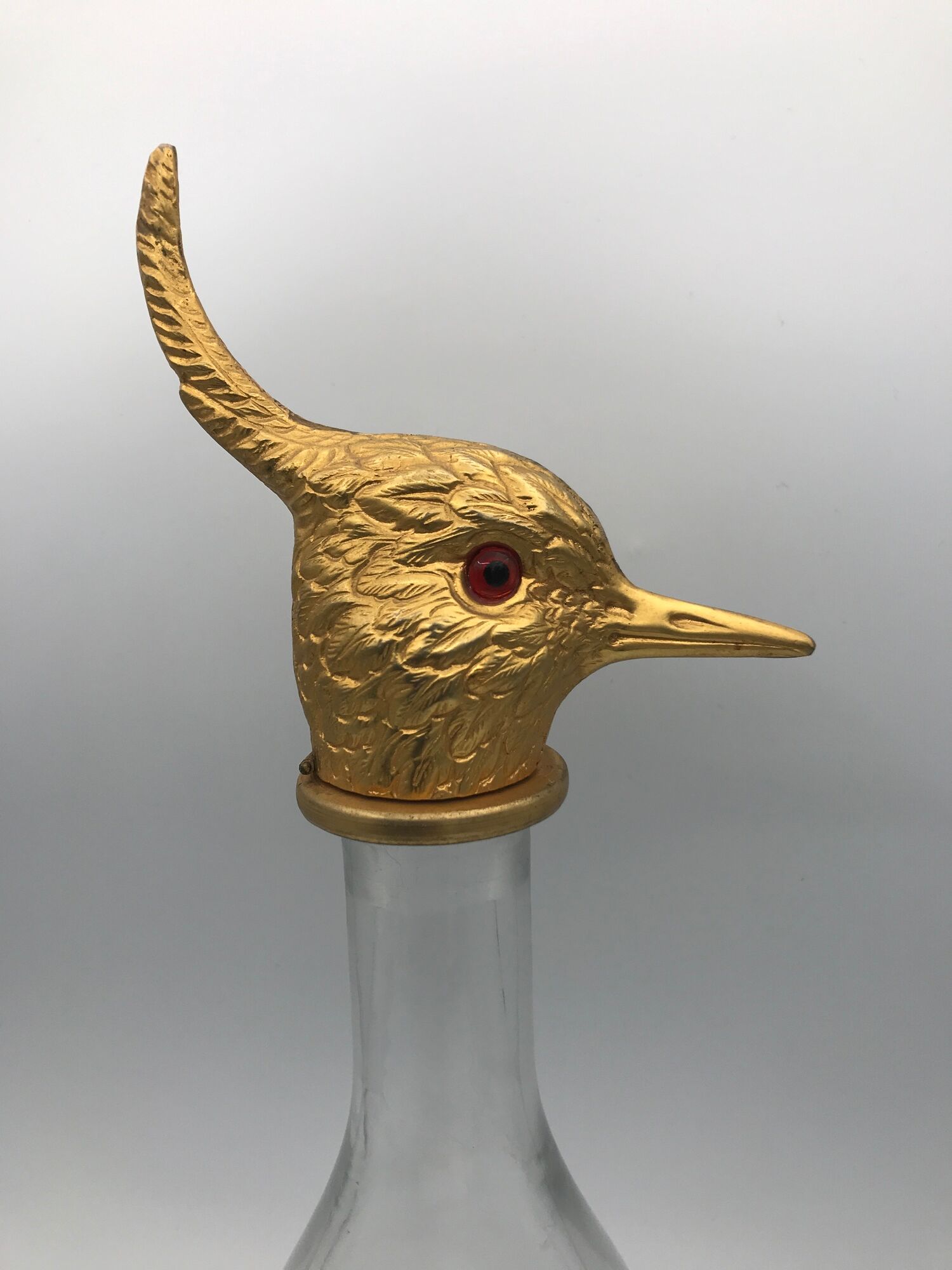 Glass bottle type carafe with gold metal bird head stopper