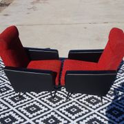 Pair of vintage armchairs in black faux leather and red fabric.