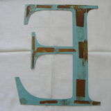 Old letter E painted metal sign
