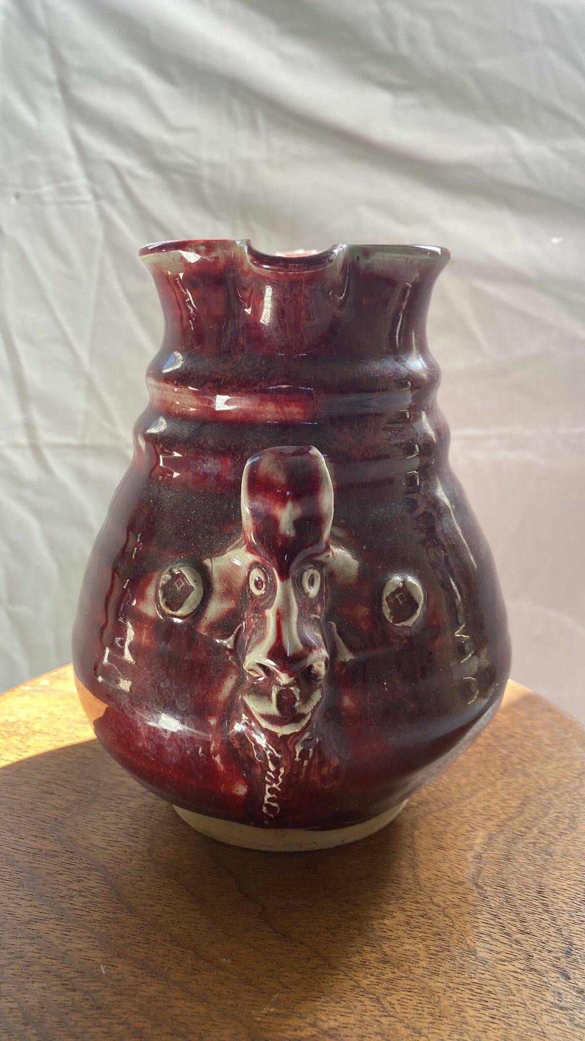 Oxblood pitcher with grotesque mask in the Delplera spirit