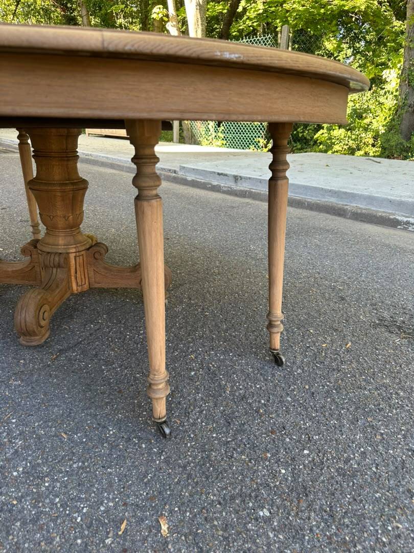 Round dining table with a central pedestal, stripped raw oak, 4 extensions, 19th century.