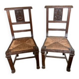 Antique carved wooden chairs with straw seats.