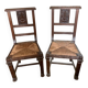 Antique carved wooden chairs with straw seats.