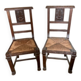 Antique carved wooden chairs with straw seats.