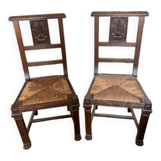 Antique carved wooden chairs with straw seats.