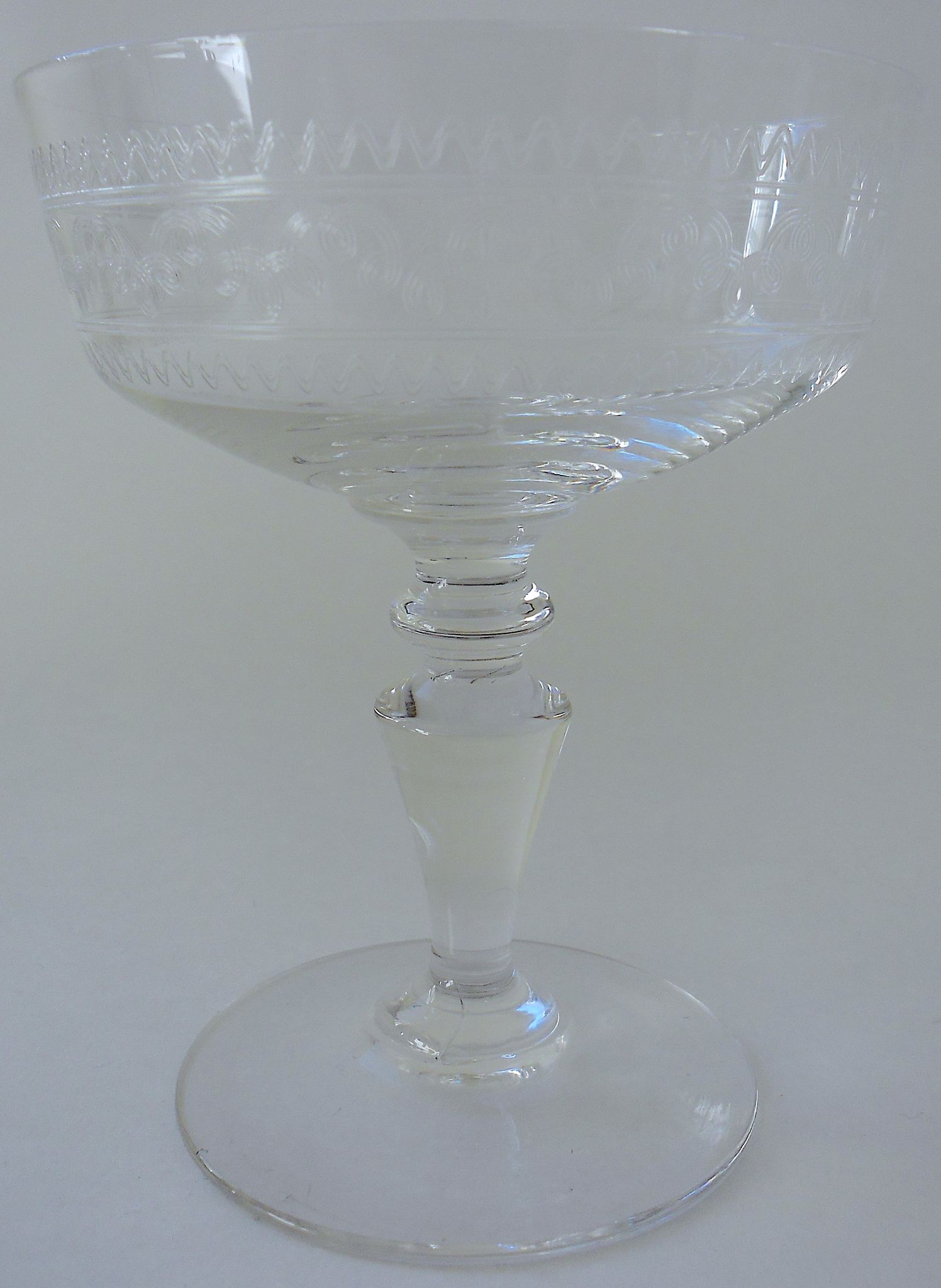 Suite of six champagne glasses on foot in engraved colorless crystal